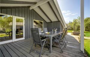 a wooden deck with a table and chairs on it at 3 Bedroom Awesome Home In Middelfart in Middelfart