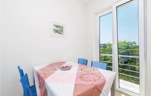a dining room with a table and chairs and a window at Nice Apartment In Barbat With 2 Bedrooms And Wifi in Barbat na Rabu