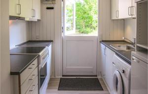 a kitchen with white cabinets and a sink and a window at 3 Bedroom Gorgeous Home In Aakirkeby in Vester Sømarken