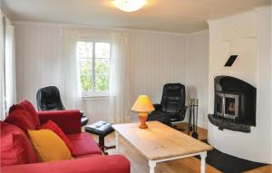 - un salon avec un canapé rouge et une cheminée dans l'établissement Pet Friendly Home In rjng With Kitchen, à Årjäng