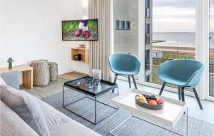 ein Wohnzimmer mit 2 Stühlen und einem Tisch mit einer Obstschale in der Unterkunft Nice Apartment In Lembruch-dmmer See With Kitchen in Lembruch