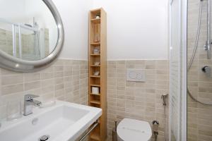 a bathroom with a sink and a toilet and a mirror at Houspitality Caesar Bed & Breakfast in Rome