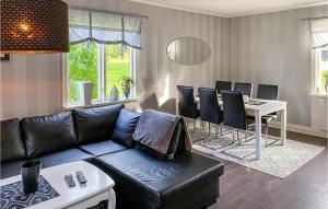 een woonkamer met een bank en een tafel met stoelen bij Nice Home In Boxholm With Kitchen in Boxholm