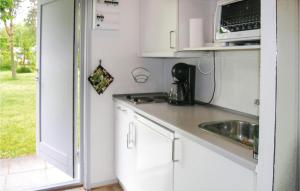 una pequeña cocina con fregadero y microondas en Nice Apartment In Nex With Outdoor Swimming Pool, en Bedegård
