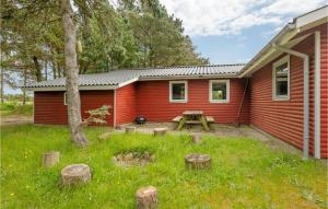 a red cabin with a picnic table in the yard at Nice Home In Rm With House Sea View in Rømø Kirkeby