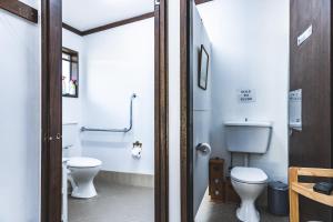 a bathroom with a toilet and a sink at Unwind Escapes Cabins & Glamping in Dooralong