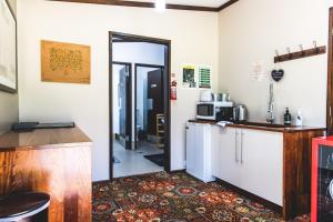 a kitchen with a refrigerator and a counter with a microwave at Unwind Escapes Cabins & Glamping in Dooralong
