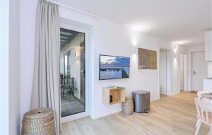 レンブルッフにあるBeach Front Apartmentの白い壁のリビングルーム、ガラスのスライドドア