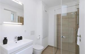 レンブルッフにあるBeach Front Apartmentのシャワーと洗面台を備えた白いバスルーム
