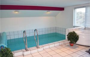 a large bathroom with a swimming pool and a tub at Pet Friendly Home In Henne With Sauna in Henne Strand