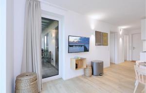 un soggiorno con pareti bianche e un grande specchio di 2 Bedroom Lovely Apartment In Lembruch-dmmer See a Lembruch