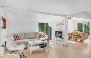 een witte woonkamer met een bank en een tafel bij Beautiful Home In Jgerspris With Kitchen in Jægerspris