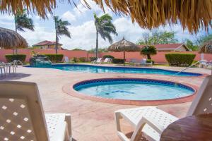 a swimming pool in a resort with chairs and a table at Sasaki Apartments in Palm-Eagle Beach