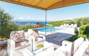 a patio with two chairs and a swimming pool at Beautiful Home In Tankaraca With Outdoor Swimming Pool in Vela Luka