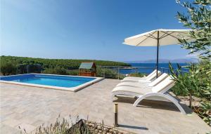 een groep stoelen en een parasol naast een zwembad bij Amazing Home In Tankaraca With 4 Bedrooms, Wifi And Outdoor Swimming Pool in Vela Luka