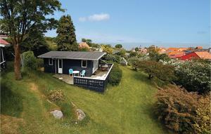una pequeña casa azul con un porche en un patio en Mlleparken en Gudhjem