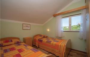 a bedroom with two beds and a window at Beautiful Home In Tankaraca With Outdoor Swimming Pool in Vela Luka