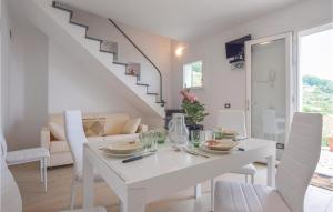 biała jadalnia z białym stołem i krzesłami w obiekcie La Casa Rossa w mieście Framura