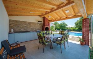 een patio met een tafel en stoelen en een zwembad bij Nice Home In Svetvincenat With Outdoor Swimming Pool in Svetvinčenat