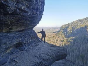 a man standing on the edge of a cliff at Villa Sonnenblick in Kurort Rathen +141 photos