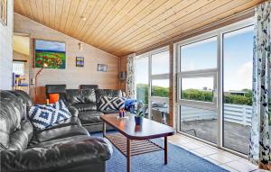 a living room with a couch and a table at Lovely Home In Knebel With Sauna in Skødshoved Strand