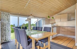 Skødshoved StrandにあるBeautiful Home In Knebel With 3 Bedrooms, Sauna And Wifiのキッチン、ダイニングルーム(木製のテーブルと椅子付)