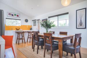 a kitchen and dining room with a wooden table and chairs at Mt Martha Retreat in Mount Martha