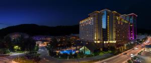 a large building with lights on a street at night at Harrah's Cherokee Casino Resort - A Caesars Rewards Destination in Cherokee