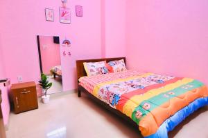 - une chambre avec un lit dans une chambre rose dans l'établissement Phương Trang Hotel Vũng Tàu, à Vung Tau