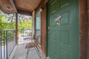 a green door on a porch with two chairs at Perfect Condo Stay Near Downtown Austin and UT in Austin