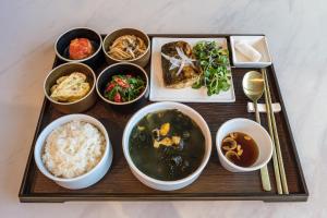 a tray with bowls of food on a table at Act Tourist Hotel in Daegu