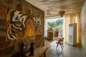 ein Zimmer mit einem Gemälde eines Tigers an der Wand in der Unterkunft Utsav Camp Sariska in Tehla