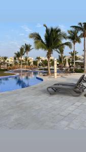 een zwembad met palmbomen naast een resort bij Hawana salalah Apartment Acacia in Salalah
