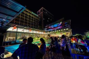 a group of people sitting at a bar in front of a building at Kingwood Hotel Sibu in Sibu