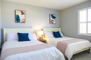 Duas camas sentadas uma ao lado da outra num quarto em Lovely Beach Home - 2 min walk to the beach - Game Room - Channel Islands! em Oxnard