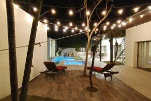 a patio with two chairs and a pool with lights at Beautiful Residence in Marina, Vallarta in Puerto Vallarta