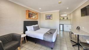 a hotel room with a bed and a kitchen at Country Leisure Motor Inn in Dubbo