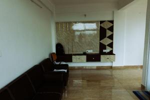 uma sala de estar com um sofá e uma janela em RVR Abode -Private Rooms em Bangalore