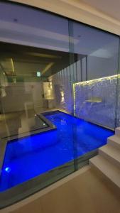 a swimming pool in a house with blue water at Boa Beach House in Porto Seguro