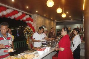 um grupo de pessoas em pé em torno de uma linha de buffet com alimentos em Victoria's Garden and Event Center em Cuenca