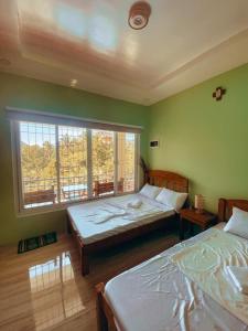 sypialnia z 2 łóżkami i oknem w obiekcie Victoria's Garden and Event Center w mieście Cuenca