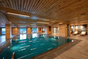 a swimming pool in a building with a wooden ceiling at Grand Kartal Hotel in Kartalkaya