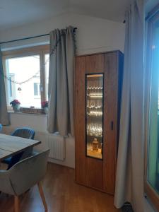 Apartment - Golden Fox 18 - Pohorske terase في هوكو بوهوجري: غرفة طعام مع خزانة مع كؤوس النبيذ
