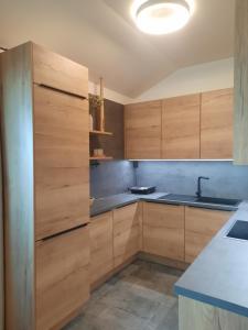 una cocina con armarios de madera y fregadero en Apartment - Golden Fox 18 - Pohorske terase, en Hočko Pohorje