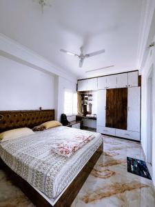 a bedroom with a large bed and a kitchen at RVR Abode -Private Rooms in Bangalore