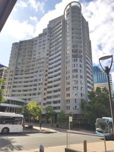 雪梨的住宿－Chatswood Hotel Apartment，一座大型建筑,前面有一辆公共汽车