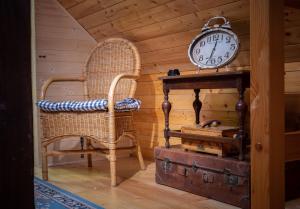 LibošoviceにあるChaloupka pod skalouの椅子と時計と荷物を備えた部屋