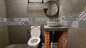 une salle de bain avec toilettes et miroir dans l'établissement Classic Traditional Villa with Breathtaking View Pool WIFI, à Pantai Cenang 7 autres photos