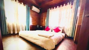 a bedroom with a large bed with red pillows at Hostmandu B&B in Pātan