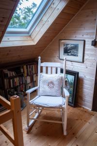 a white rocking chair in a room with a window at Chaloupka pod skalou in Libošovice